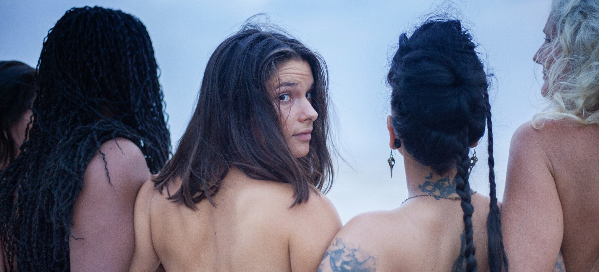 Women standing close together at dusk