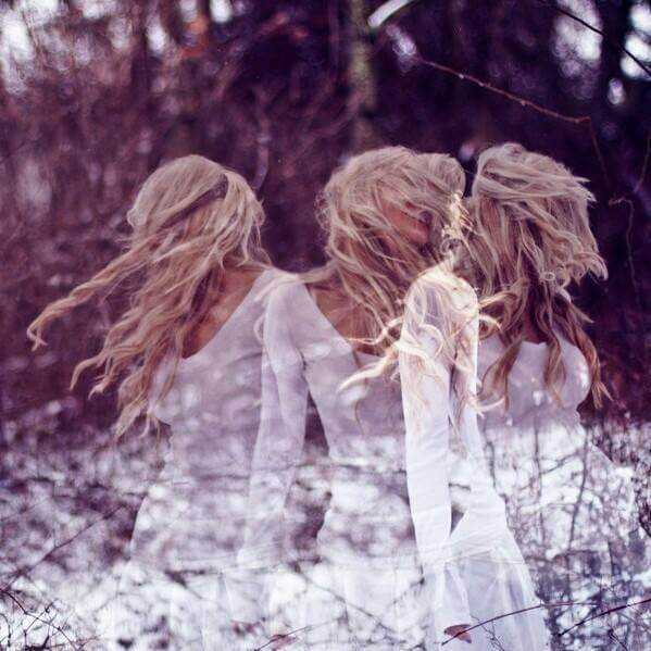 Three overlapping images of a woman with long blonde hair in a white dress, moving through a snowy winter forest